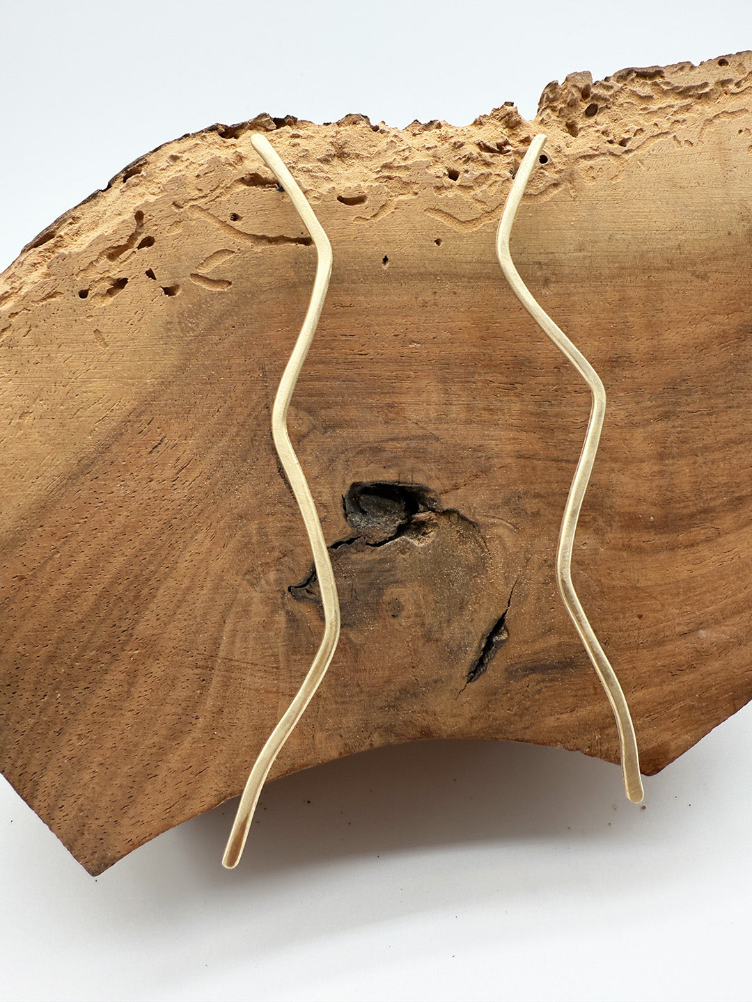 Wooden surface with two gold wires crisscrossing it