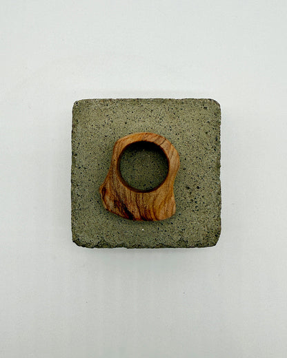 Square concrete coaster with a wooden ring on a white background