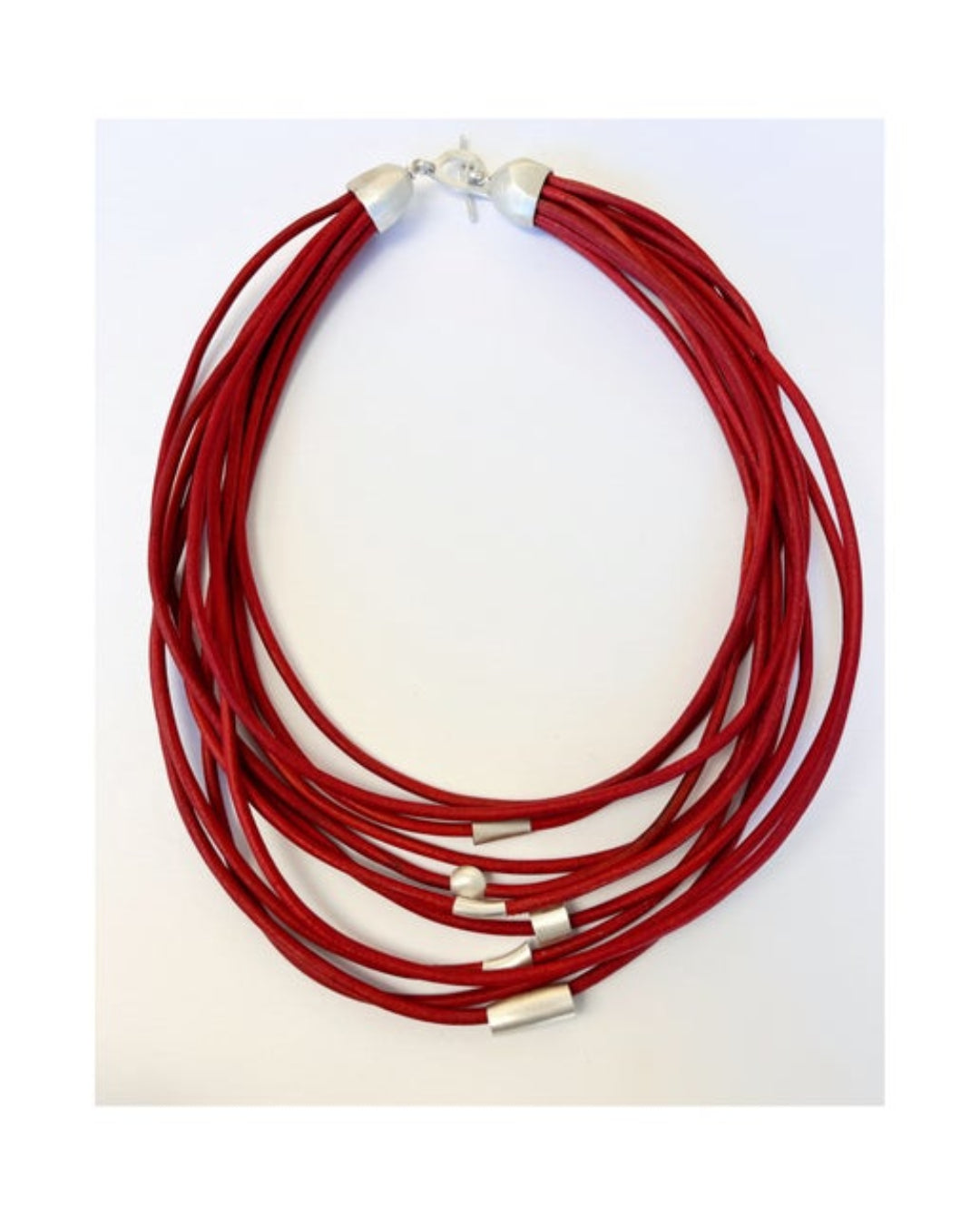 Red multistrand leather necklace with silver details on a white background