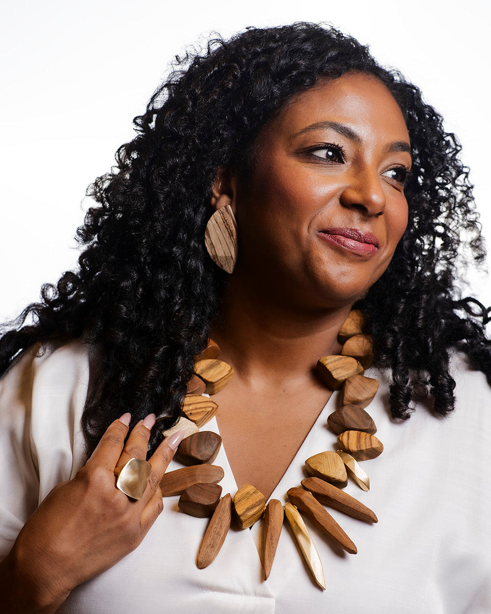 Woman wearing a wooden necklace against a white background