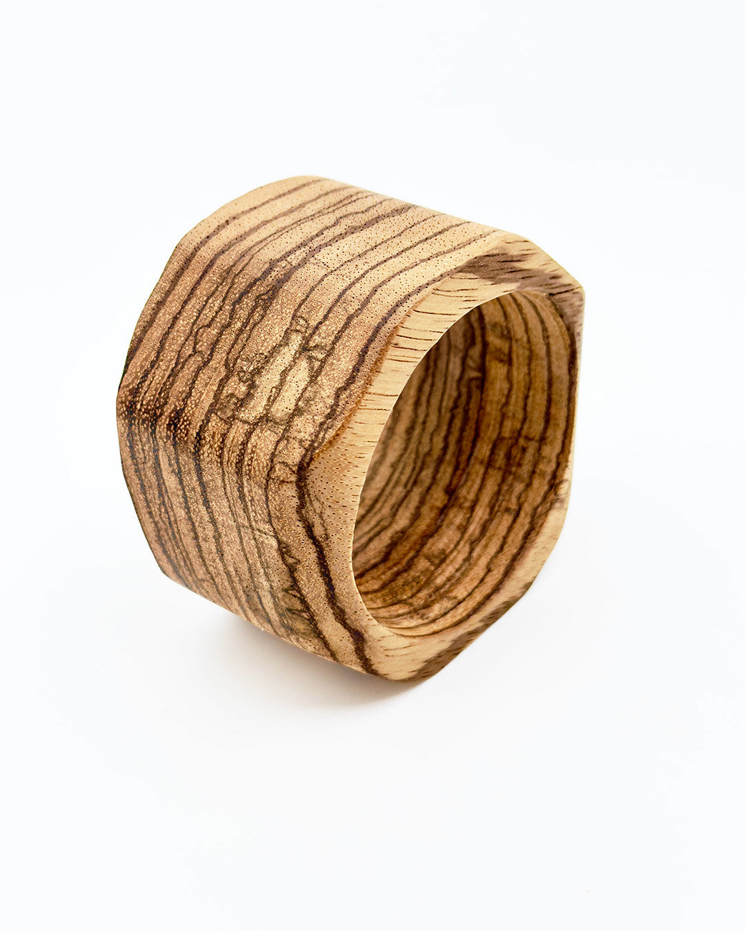 Wooden napkin ring with a zebra wood pattern on a white background