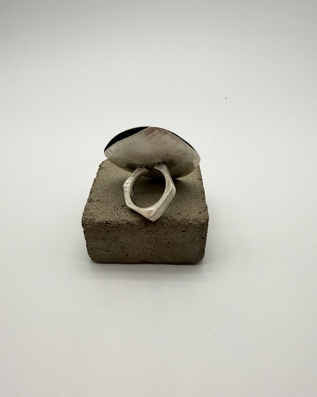 Small concrete block with a ring on a white background