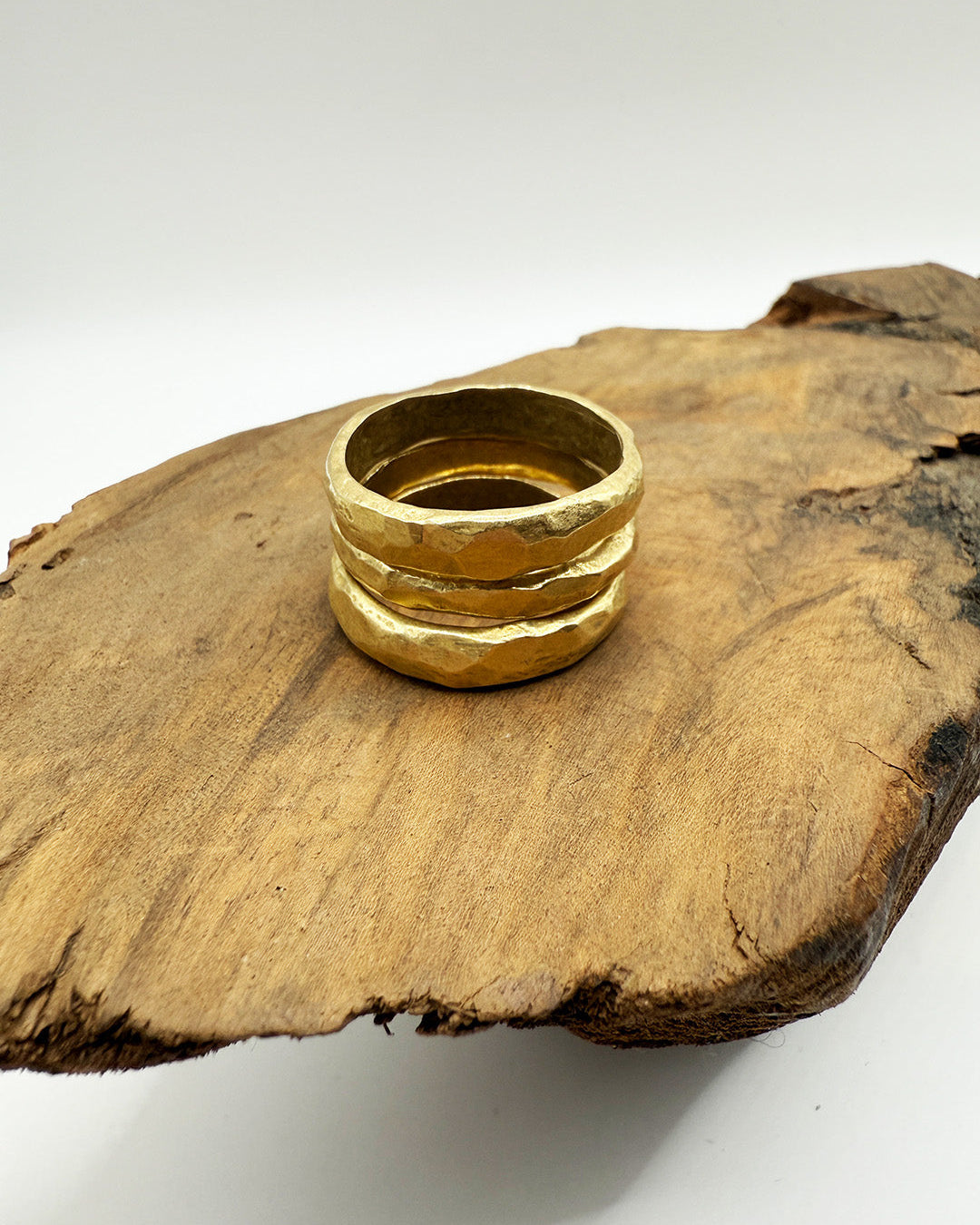 Gold ring on a wooden surface with a white background