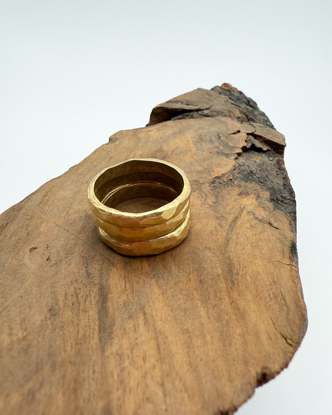 Gold ring on a wooden surface with a white background