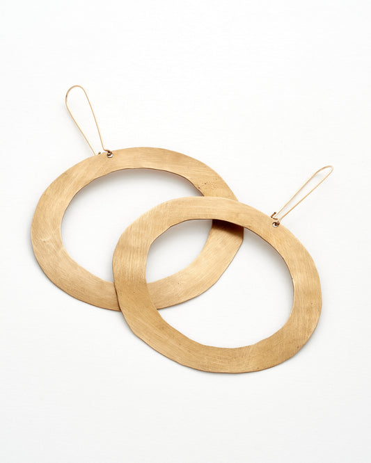 Two modern bronze hoop earrings on a white background