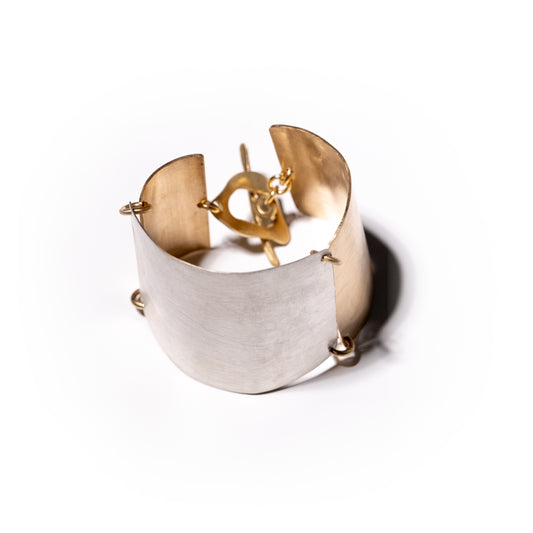Gold and silver cuff bracelet on a white background
