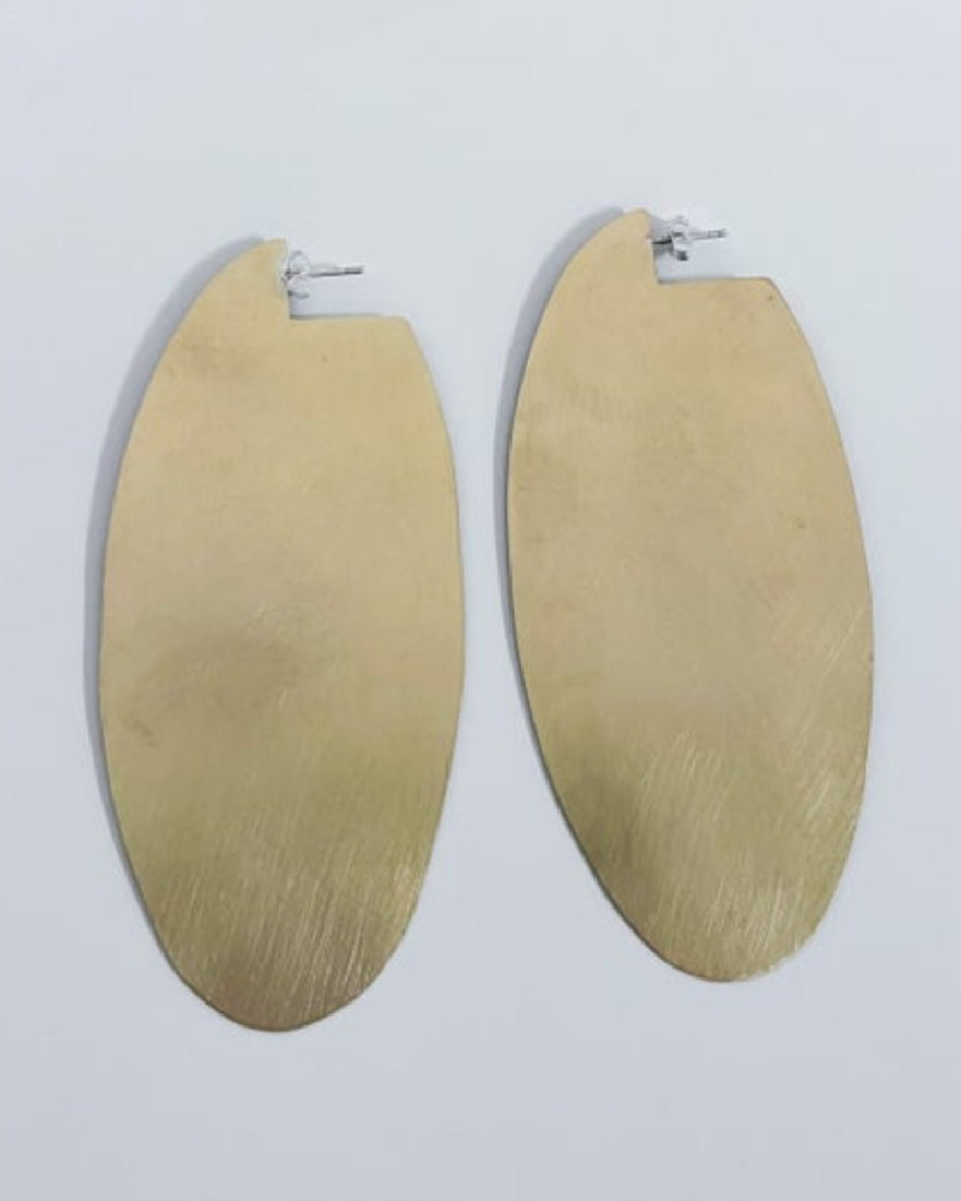 Gold oval earrings on a light gray background