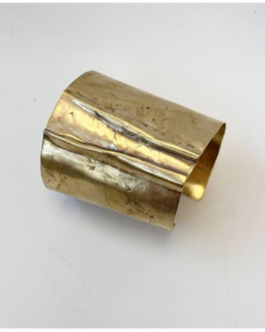 Gold cuff bracelet on a white background