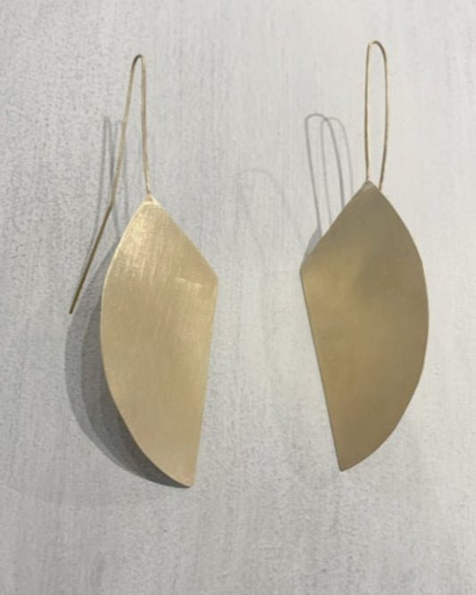 Gold leaf-shaped earrings on a light gray background