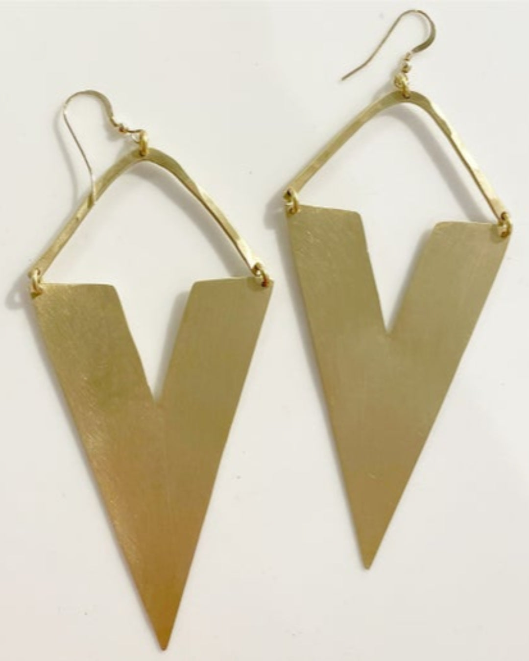 Gold inverted triangle-shaped earrings on a light grey background