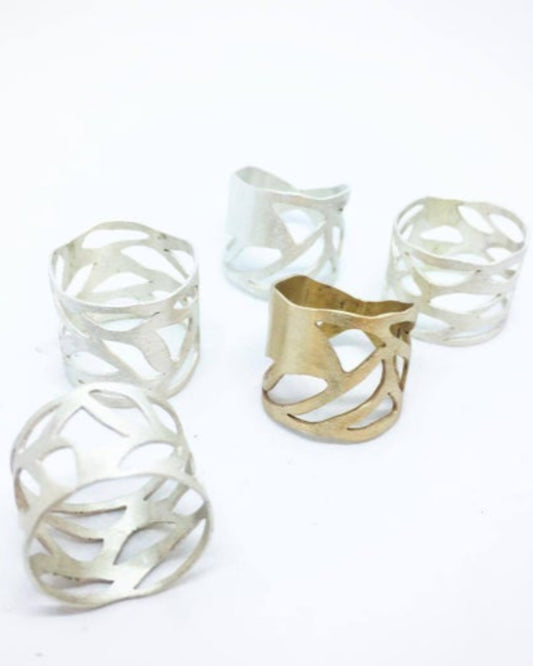 Collection of four silver rings and one bronze ring with intricate design on a white background 