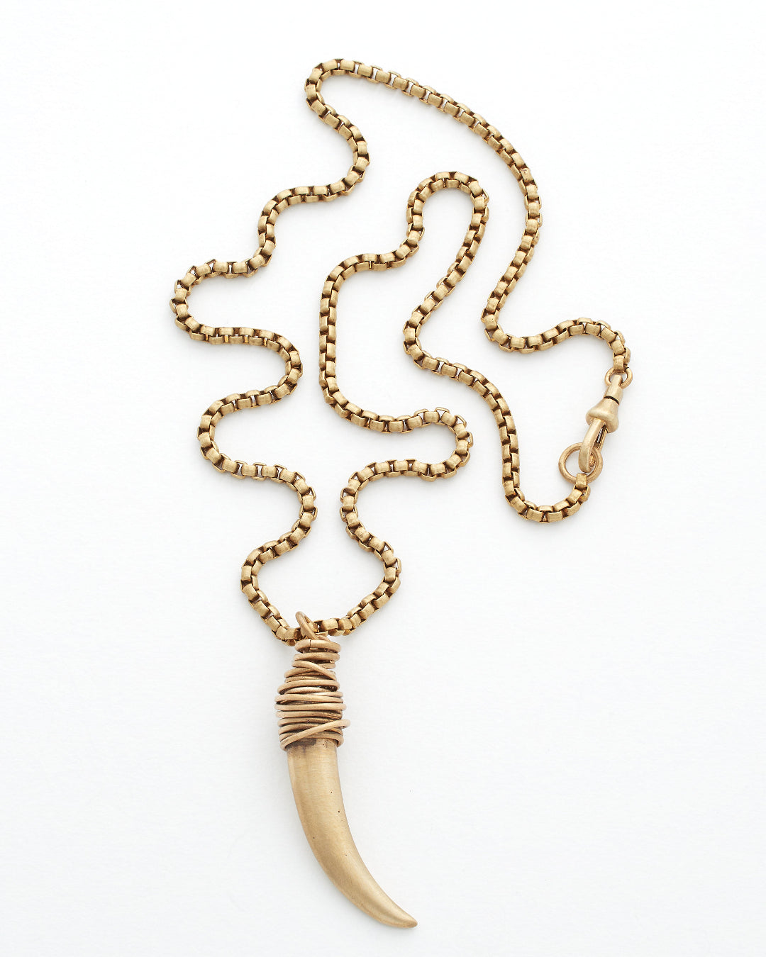 Gold necklace with a horn shaped pendant on a white background