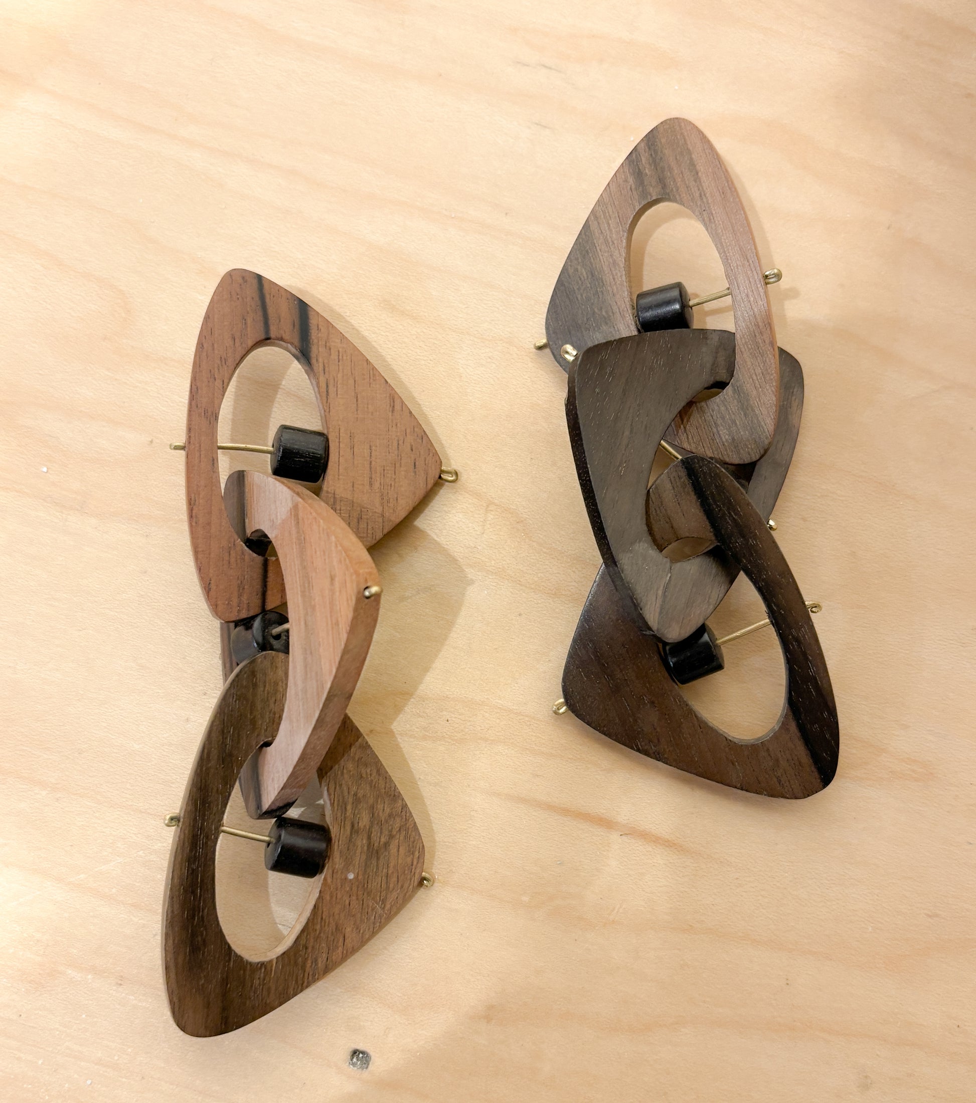 Pair or wooden geometric earrings on a  wooden surface