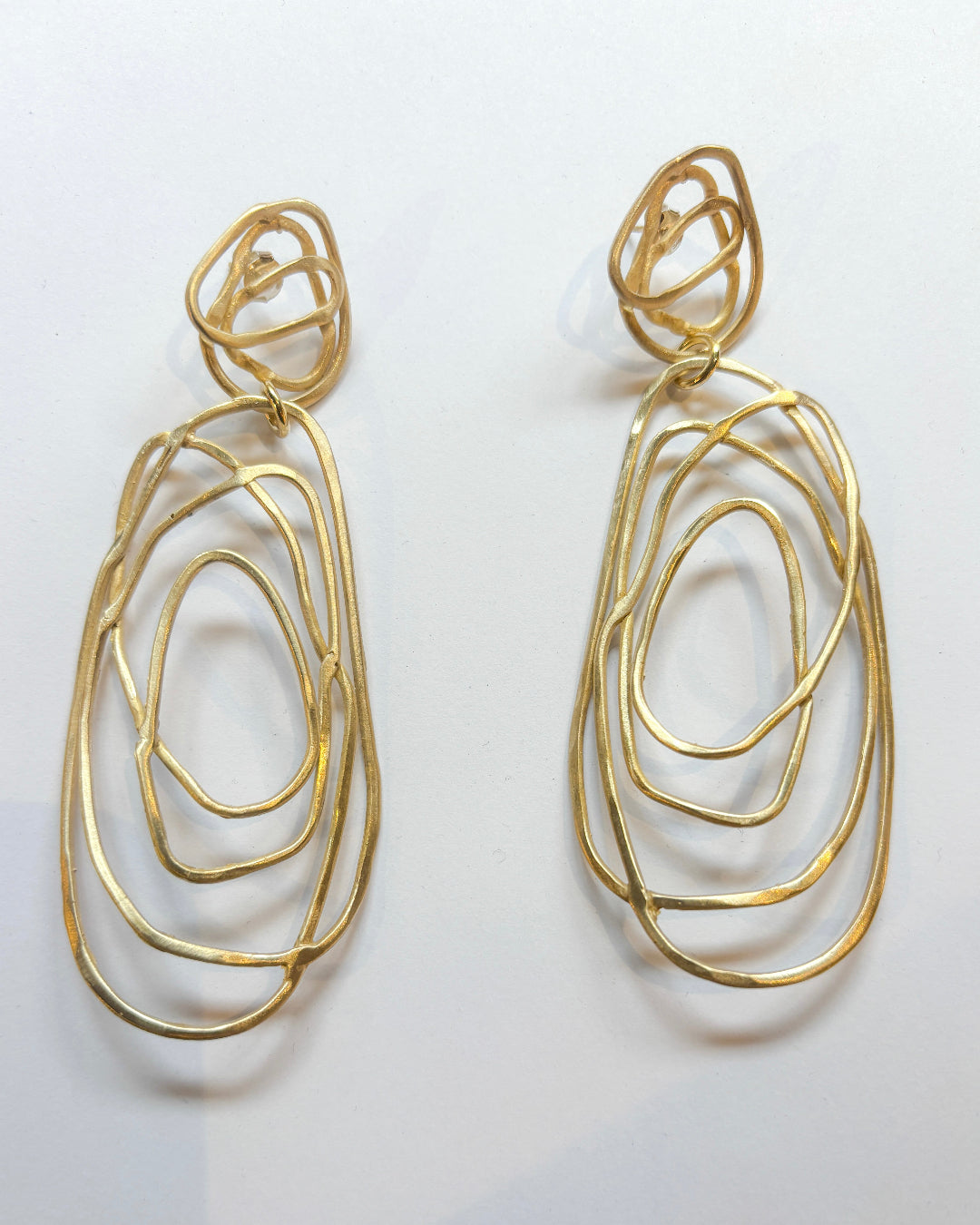 Gold wire earrings on a white background