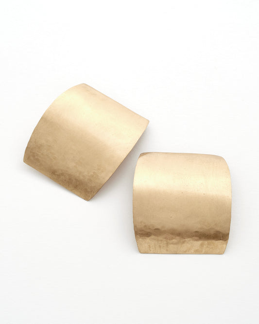 Pair of curved rectangular gold earrings on a white background