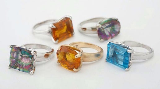 Collection of colorful gemstone rings on a white background
