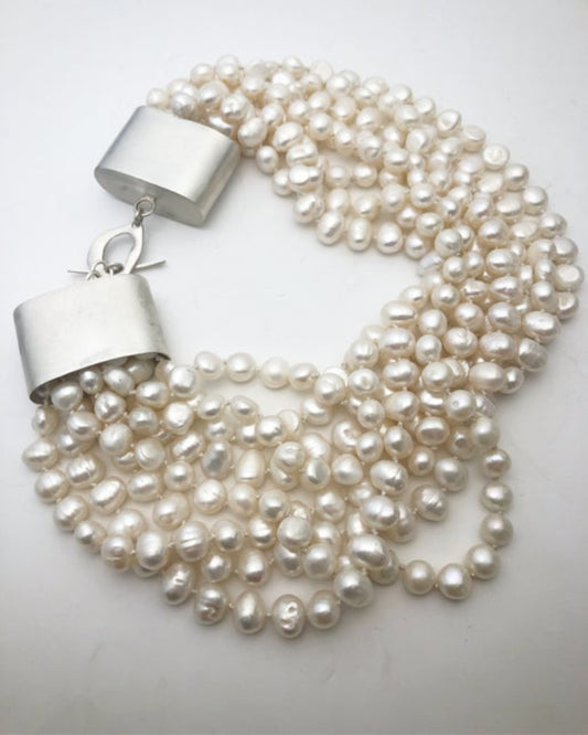 White pearl necklace with silver clasp on a white background