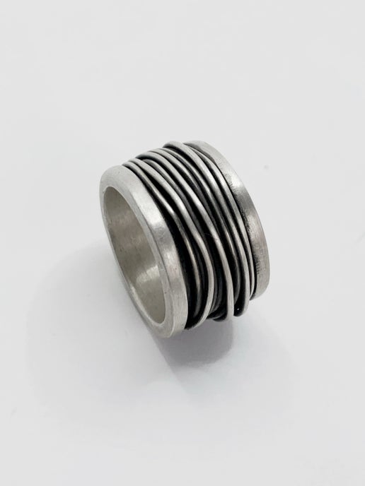 Silver ring with wire detailing on a white background