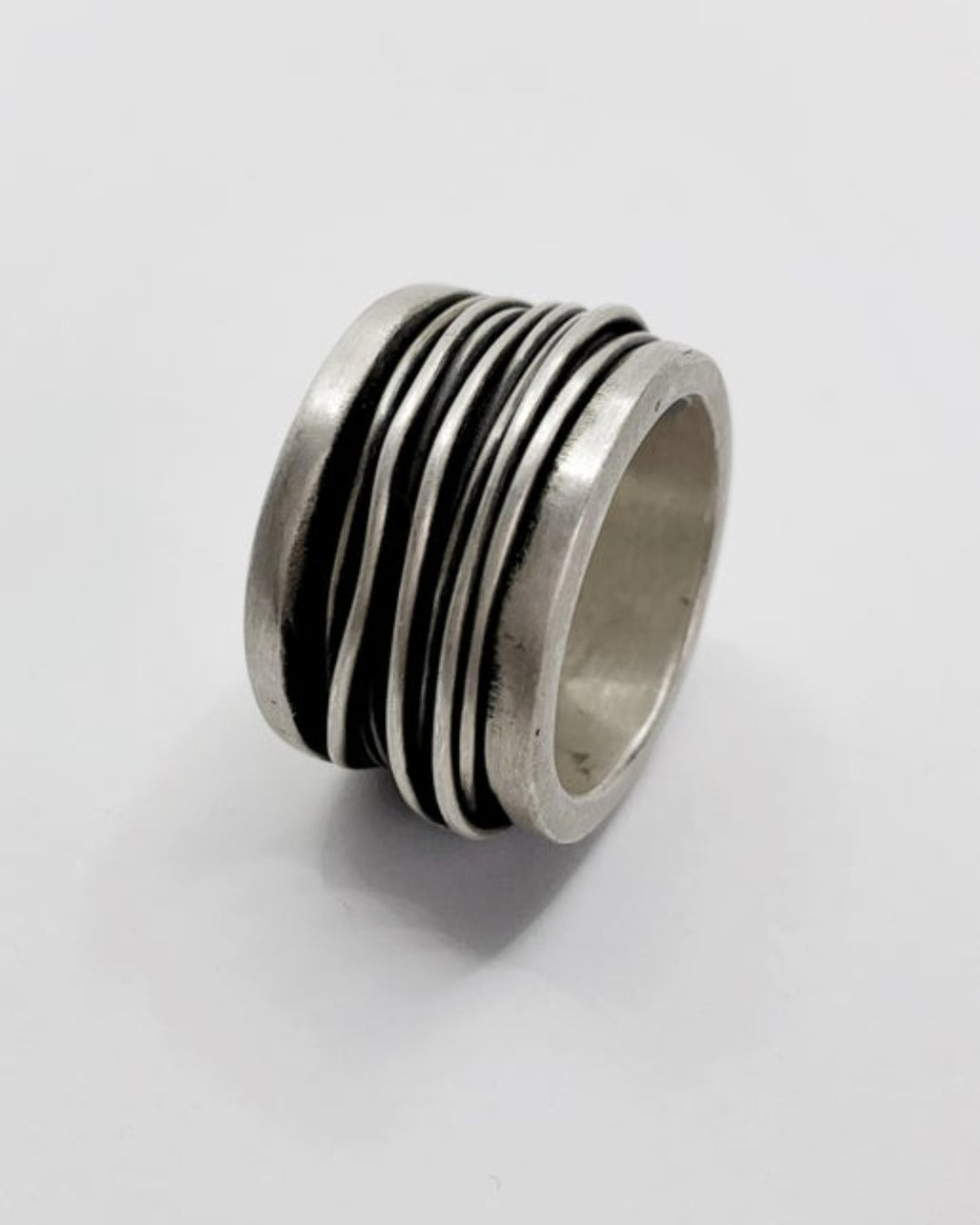 Silver ring with wire detailing on a white background
