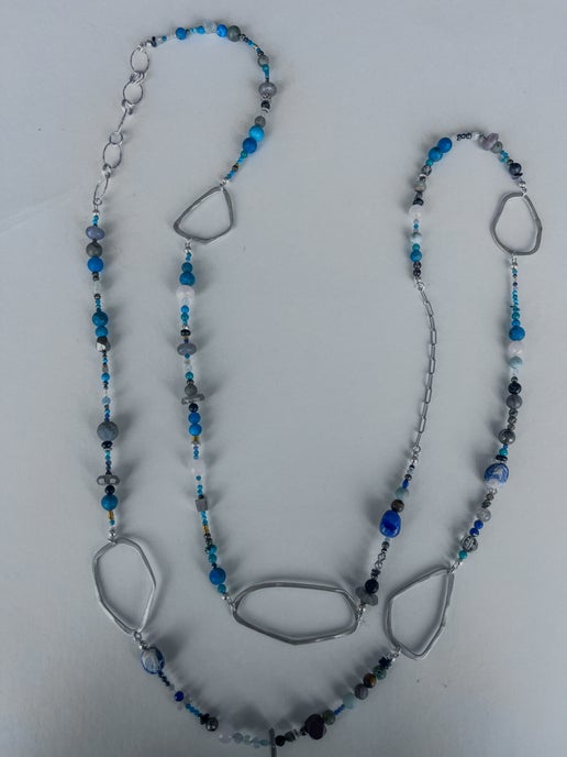Necklace with  blue and gray beads  and large circular pendants on a white background