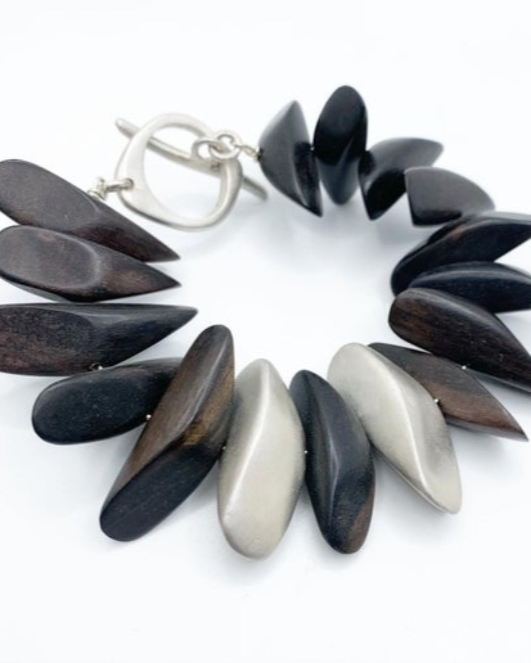 Bracelet with wooden and silver pebble-like beads on a white background