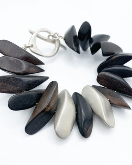 Bracelet with wooden and silver pebble-like beads on a white background