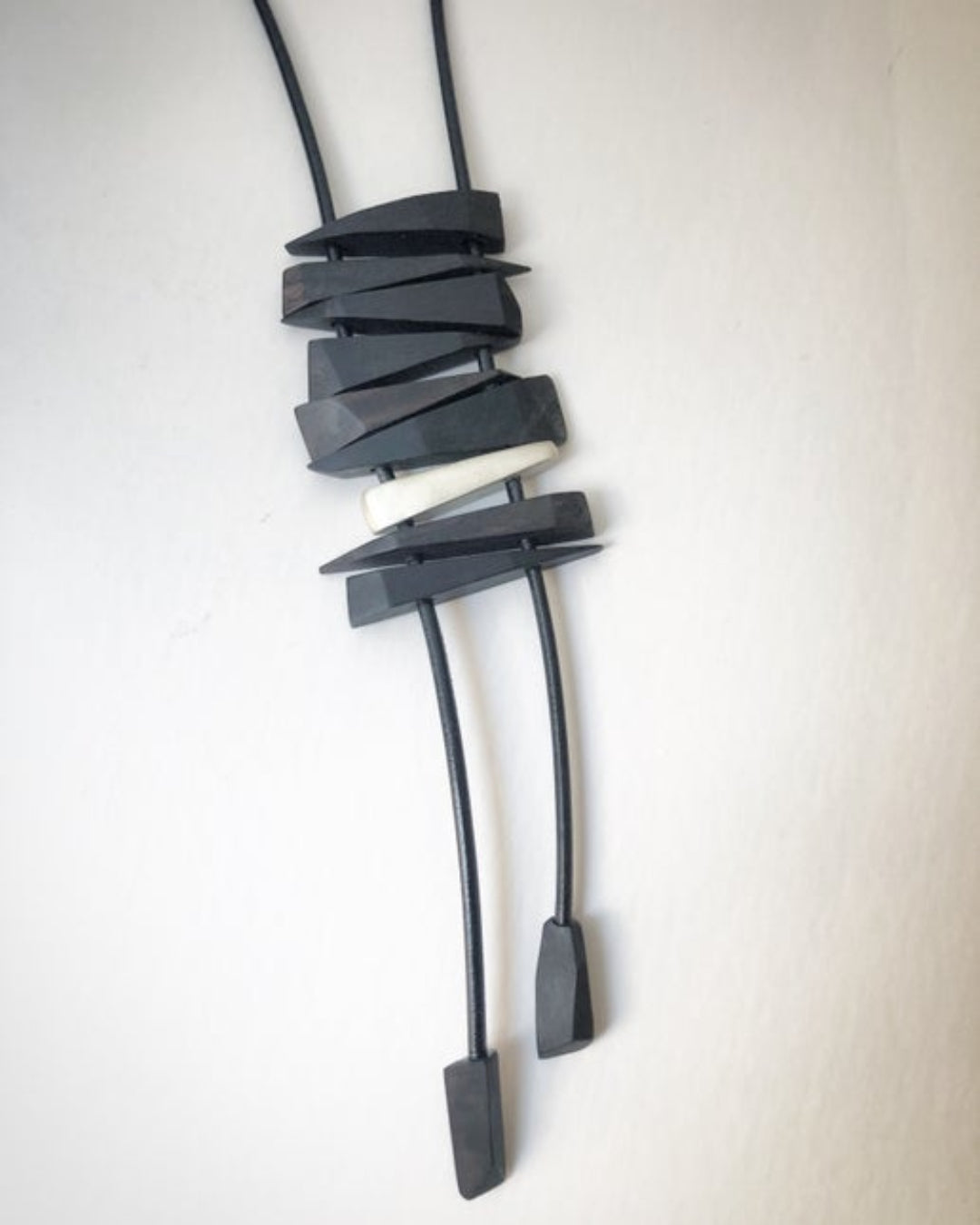 Necklace with wooden and silver fragments on a light beige background