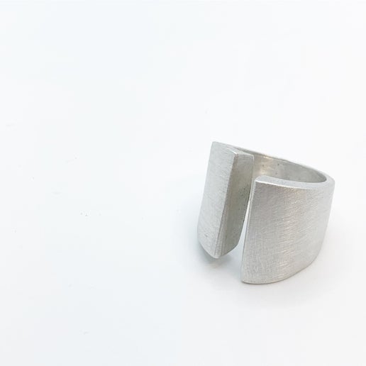 Silver ring with geometric details on a white background