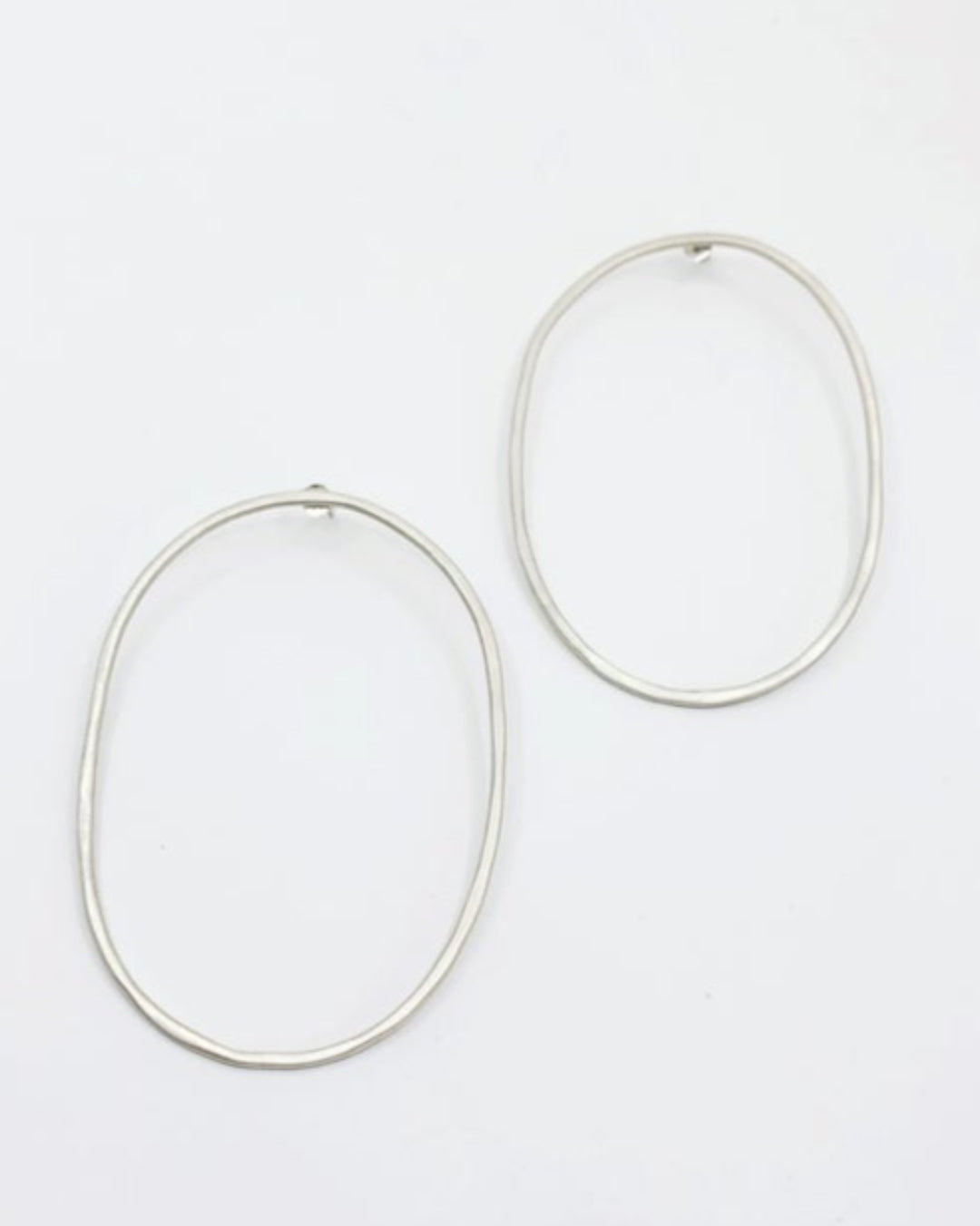 Pair of silver hoop earrings on a white background