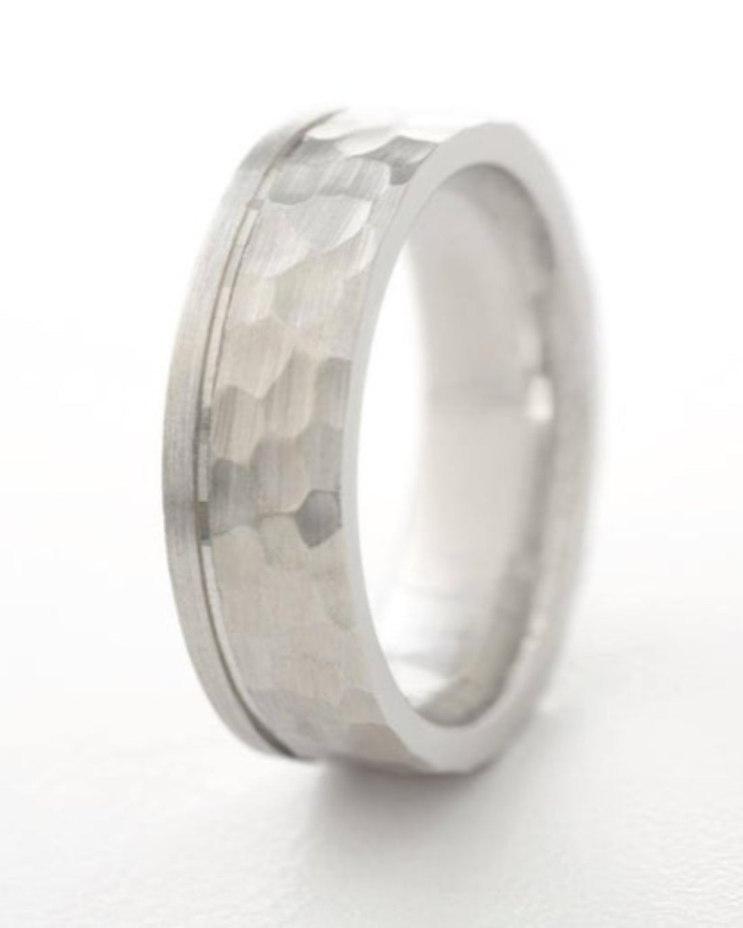 Silver ring with a textured band on a white background