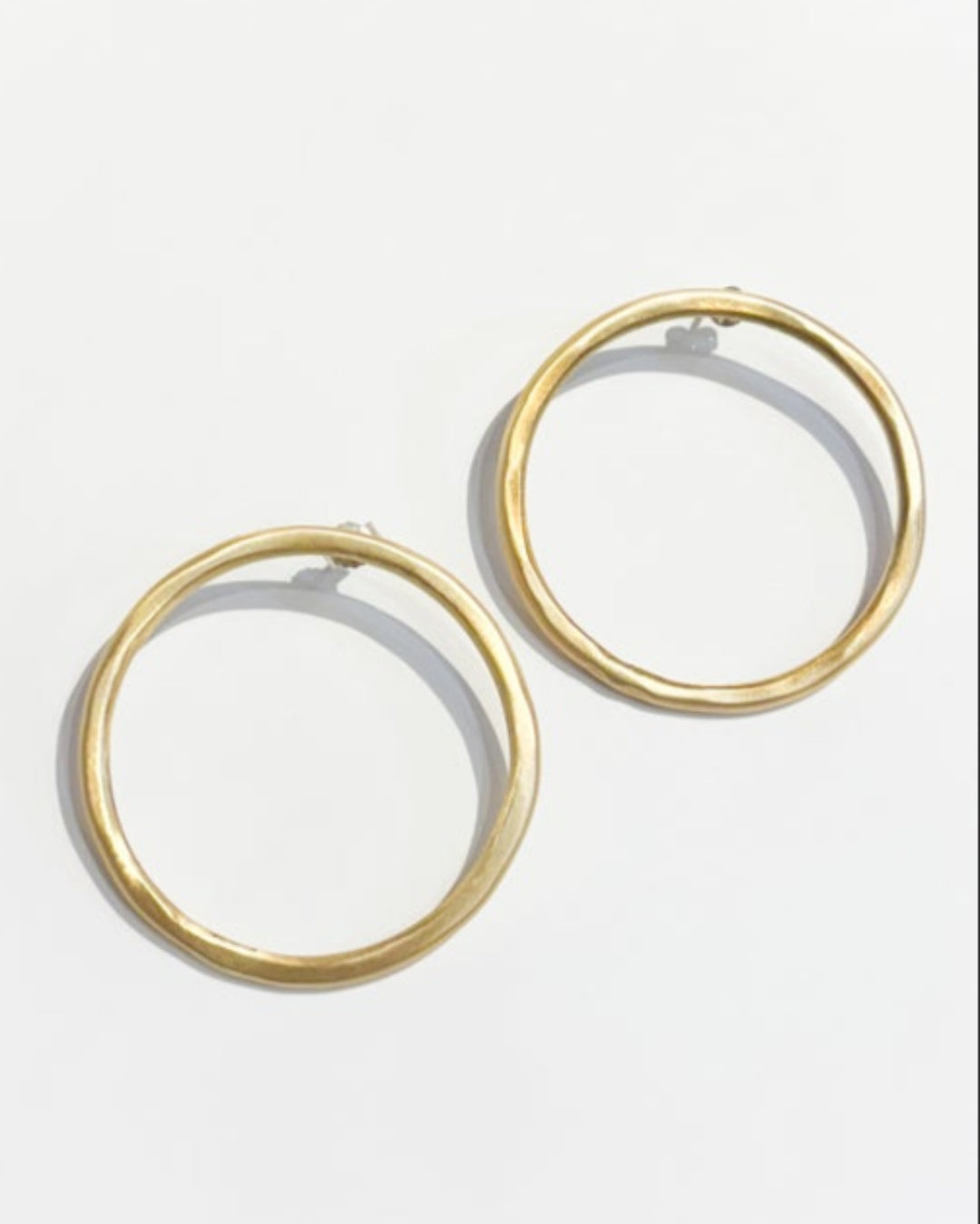 Gold hoop earrings on a light gray background