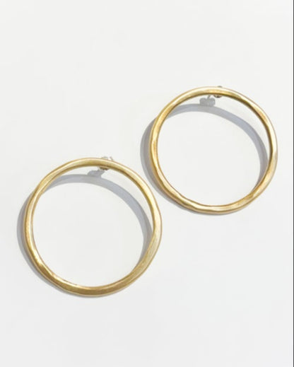 Gold hoop earrings on a light gray background