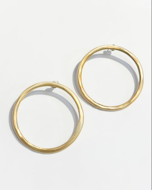 Gold hoop earrings on a light gray background