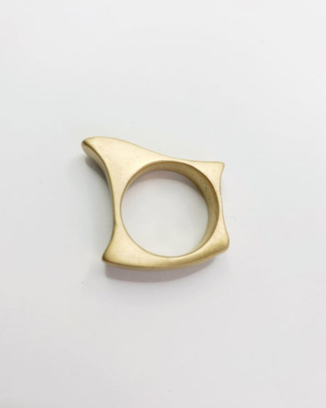 Gold ring with a geometric design on a light gray background