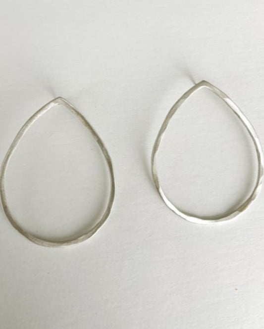 Teardrop-shaped silver earrings on a white background