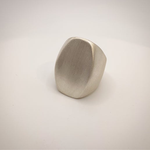 Metallic silver ring on a light gray background