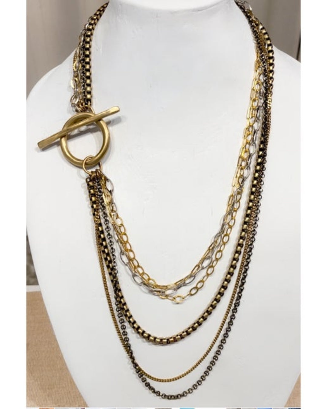 Multistrand chain necklace with a toggle clasp on a mannequin bust.