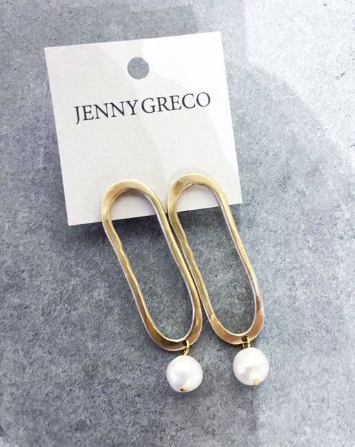 Gold hoop earrings with pearl drops on a Jenny Greco card against a gray background