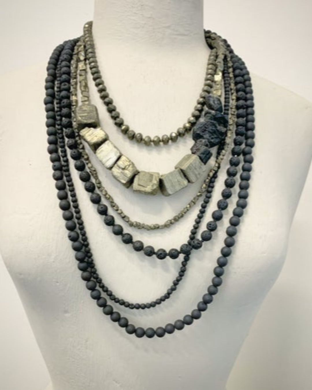 Multi-strand beaded necklace on a mannequin bust