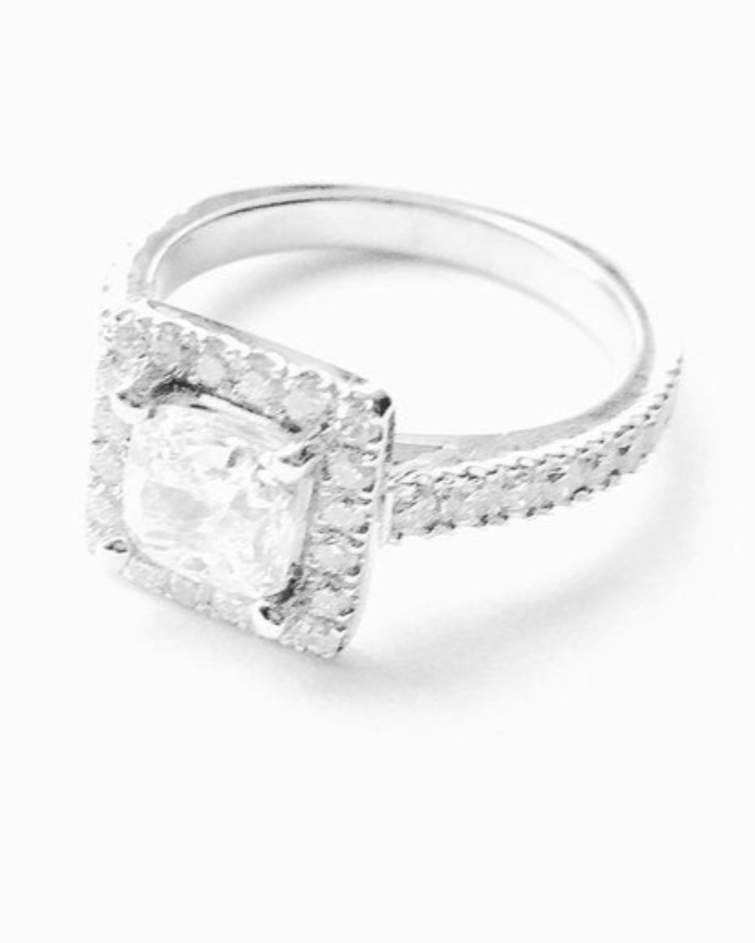Silver ring with a  diamond band and large feature diamond on a white background