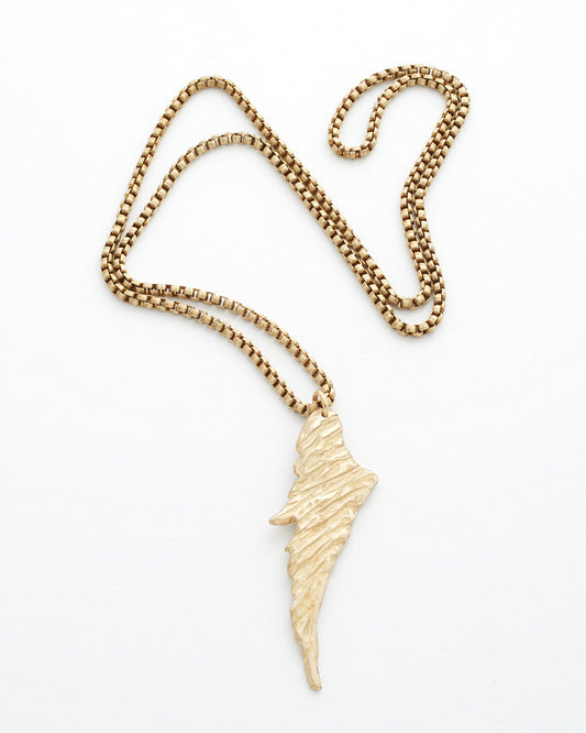 Gold necklace with a wing-shaped pendant on a white background