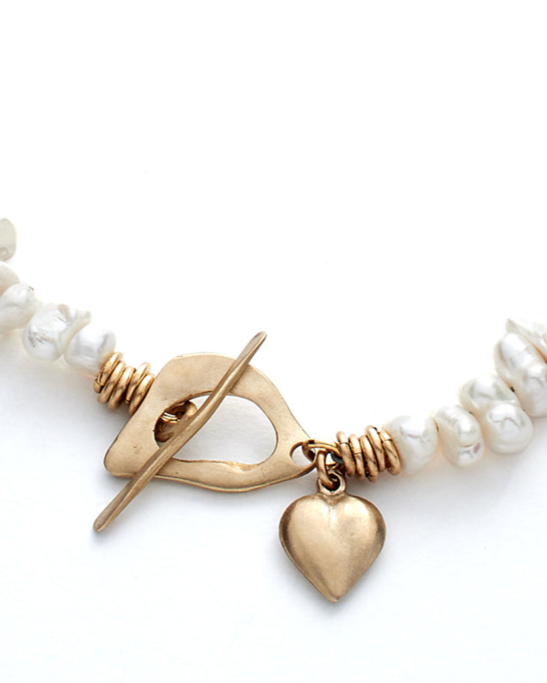 Necklace with gold heart charm and pearl beads on a white background