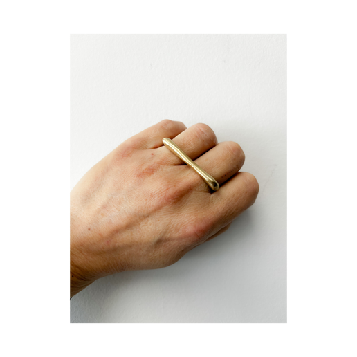 Gold ring on a hand against a white background