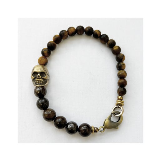 Brown beaded bracelet with bronze skull charm on a white background