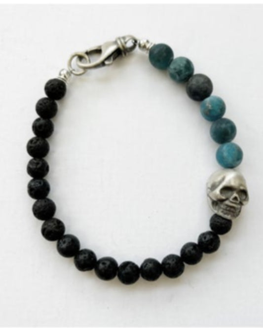 Beaded bracelet with black and blue beads and a silver skull charm on a white background