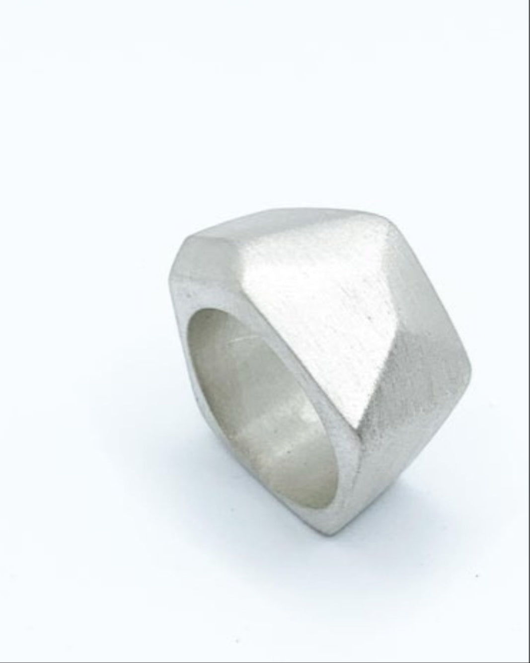 Silver ring with geometric design on a neutral background