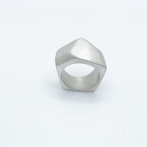 Silver geometric ring on a neutral background