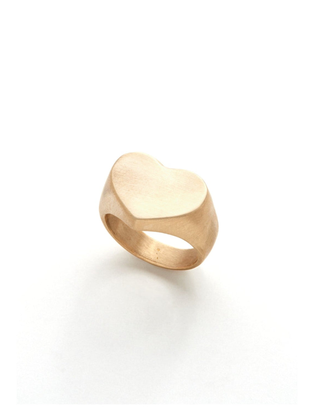 Gold heart-shaped ring on a white background