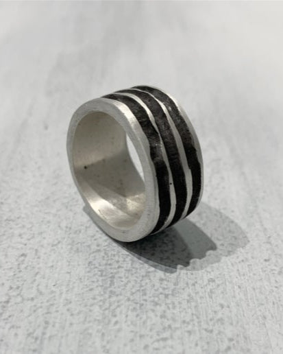 Silver textured ring on a white surface