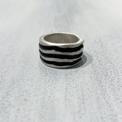 Silver textured ring on a light gray background